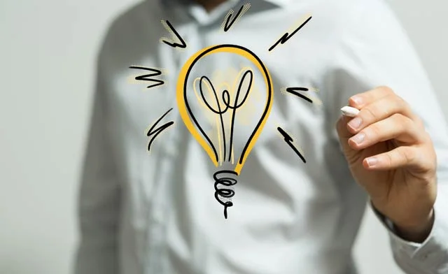 un homme qui dessine une ampoule