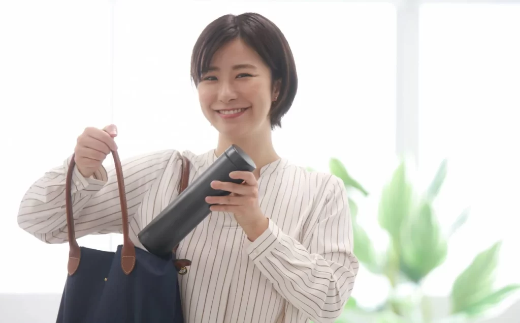 une femme d'origine asiatique avec sa gourde dans son sac