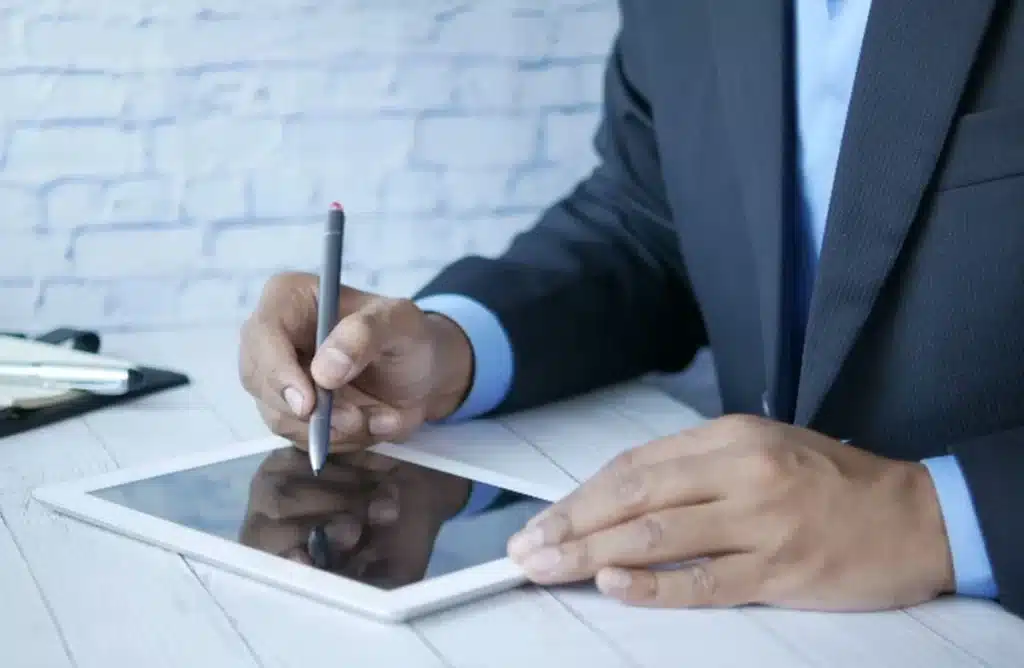 un business man qui signe sur une tablette