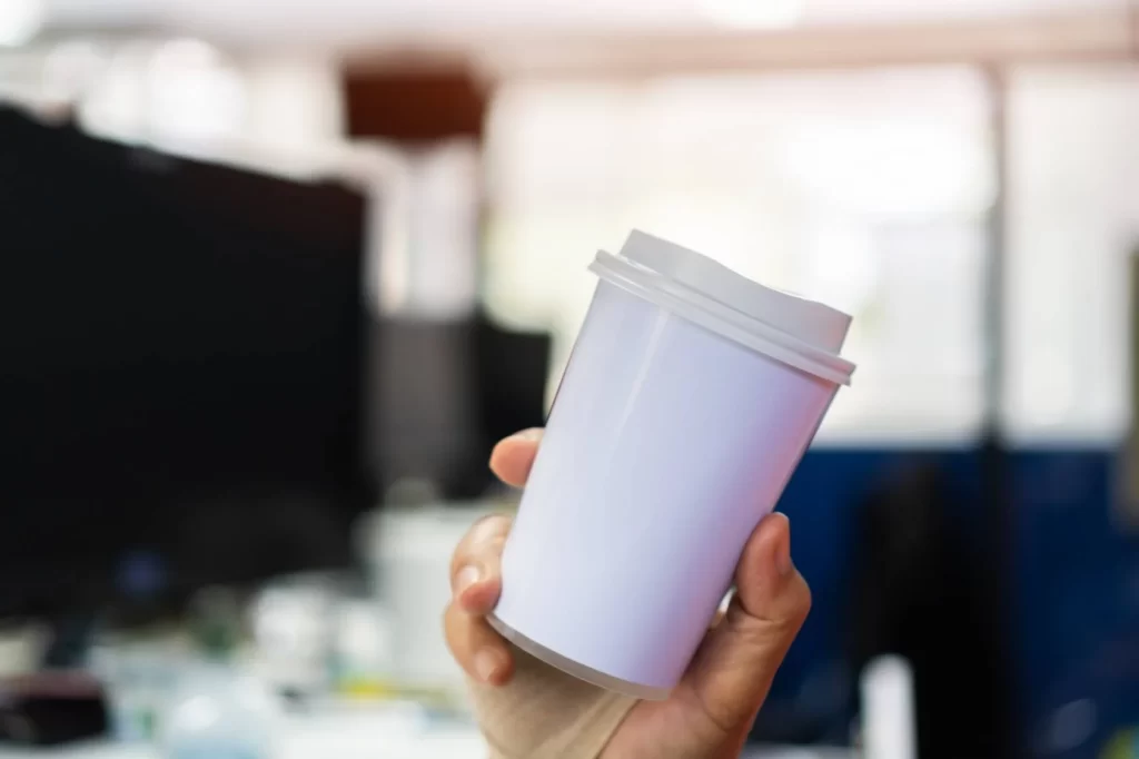 un gobelet dans une main