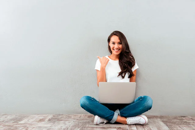 une jeune entrepreneuse qui lève le pousse avec son pc