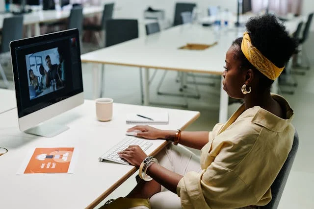 une femme qui regarde une vidéo sur son mac