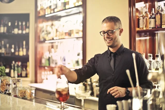 un barman en train de servir un cocktail