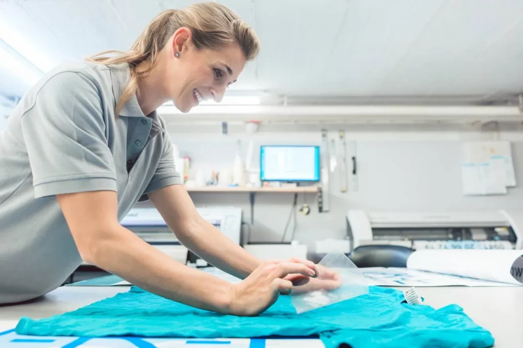 une femme en train de floquer un t-shirt