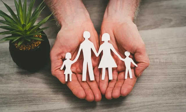 une famille en papier dans des mains