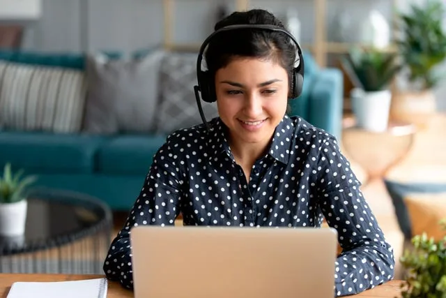 une freelance devant son pc avec un casque