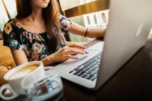 une femme qui travaille dans un café sur son pc