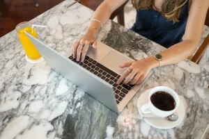 une freelance devant son pc avec un café