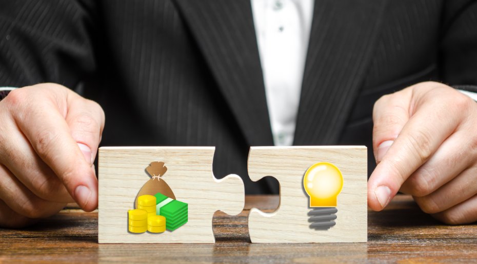 Une personne avec 2 pièces de puzzle avec une ampoule et de l'argent