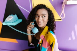 une jeune femme avec un vieux téléphone fixe