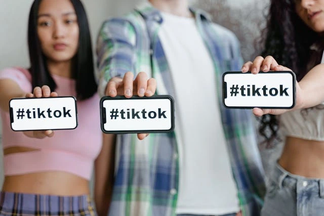 3 personnes qui montrent leur téléphone avec marqué Tiktok