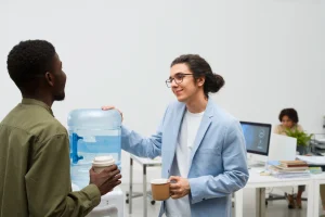 un homme et une femme devant une bombonne d'eau