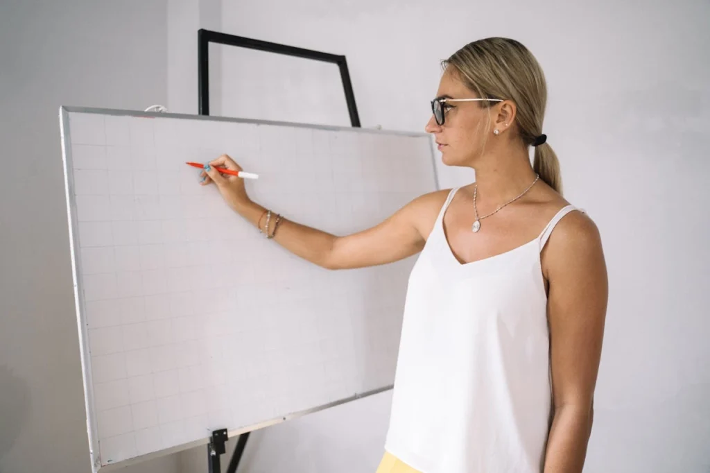 un tableau blanc avec une femme qui écrit