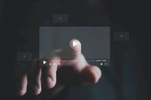 un doigt qui appuie sur play sur une vidéo par transparence