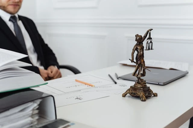 un juriste avec une statuette de la justice sur le bureau