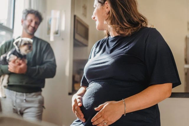 une femme enceinte et un homme avec un chien