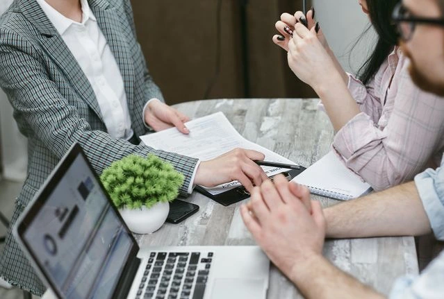 3 personnes autour d'un contrat d'assurance
