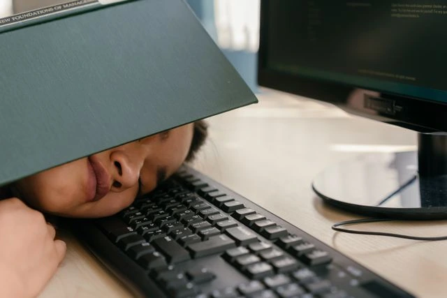 une freelance épuisée qui dort sur son bureau