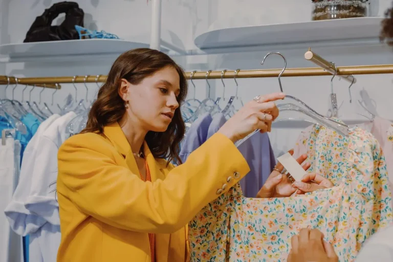 une femme qui range dans un magasin de prêt à porter