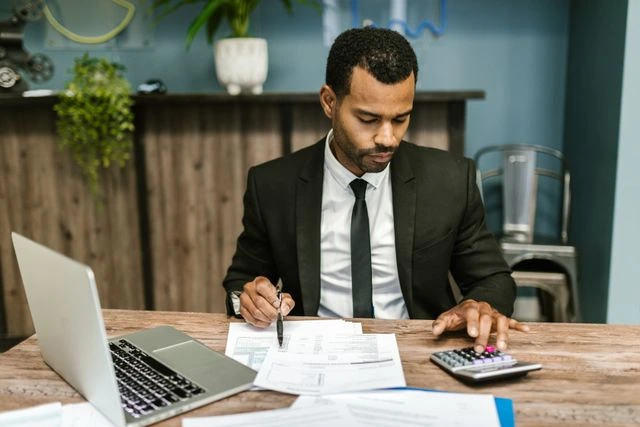 un entrepreneur qui utilise une calculatrice