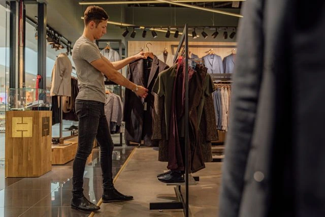 un client qui regarde des habits dans un magasin physique
